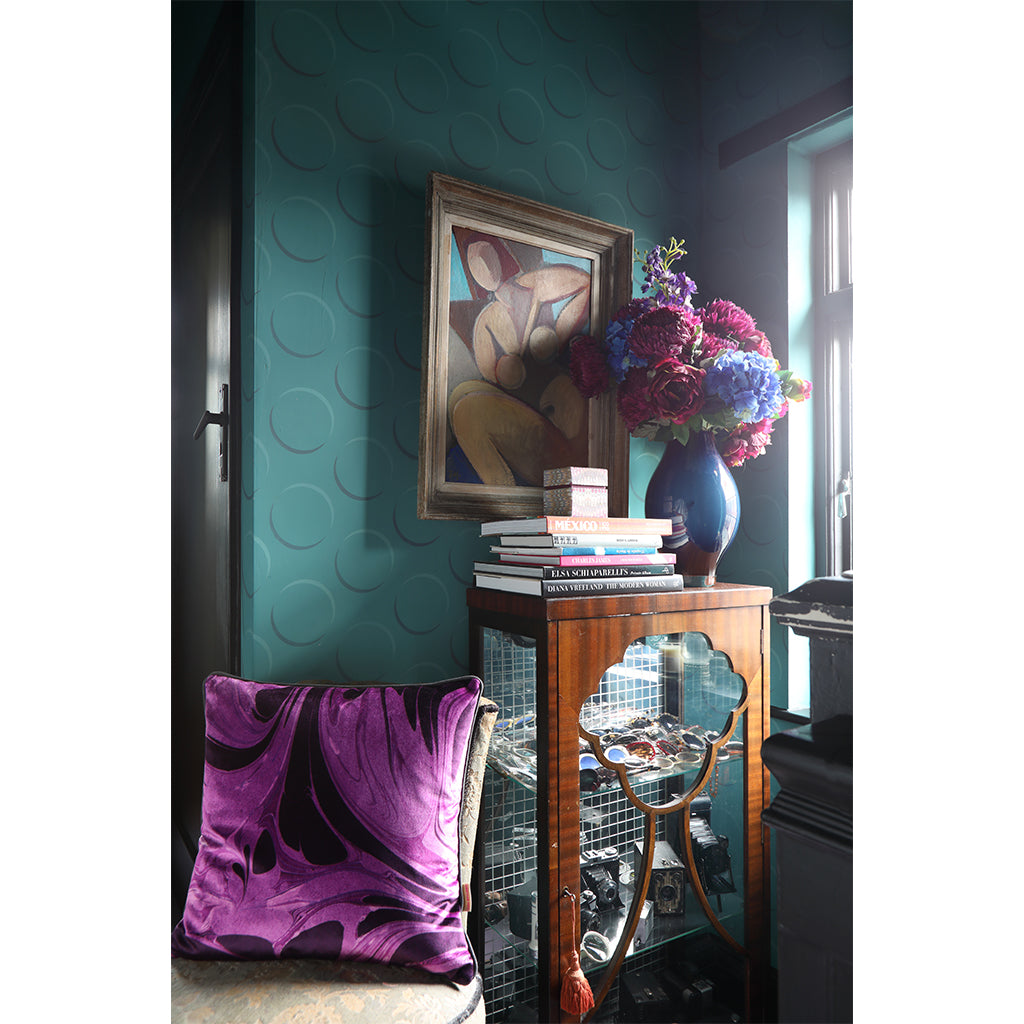 Bright purple patterned cushion on chair in hallway