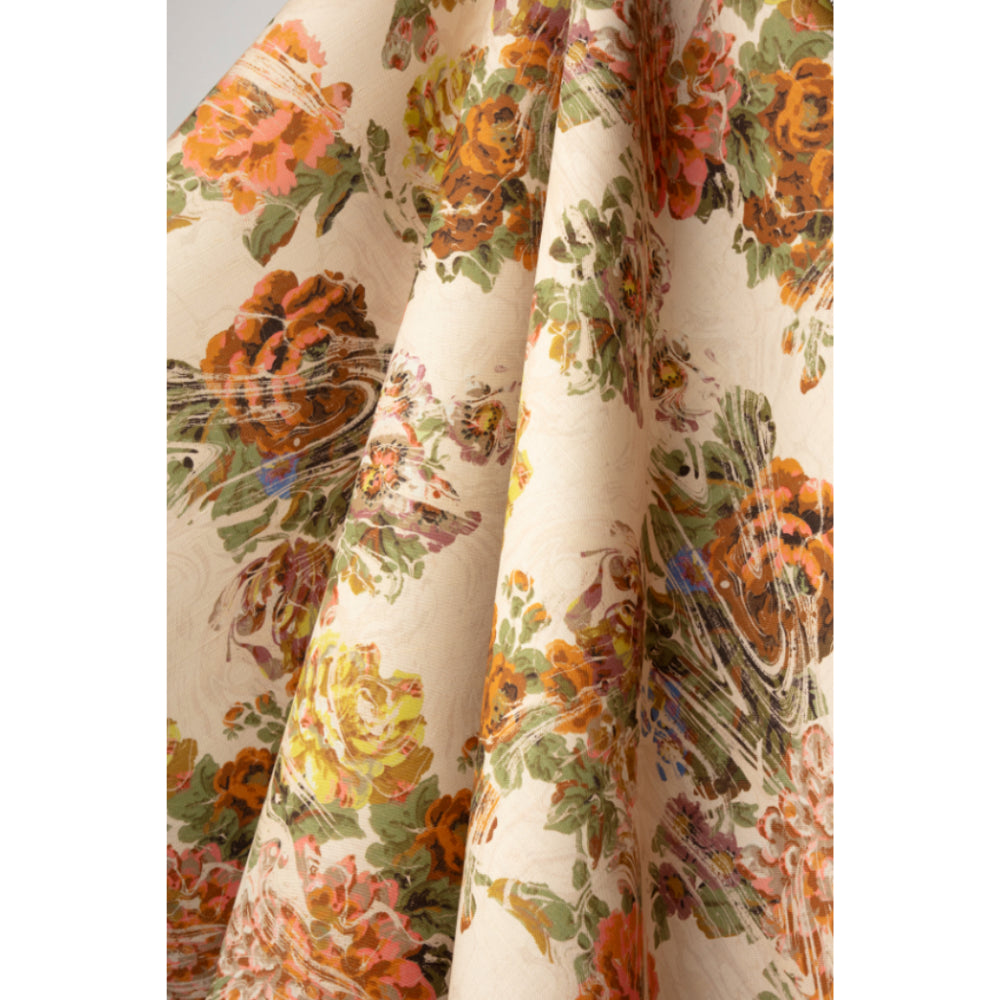Floral patterned fabric with green foliage and yellow, pink and red flowers on a beige marbled background