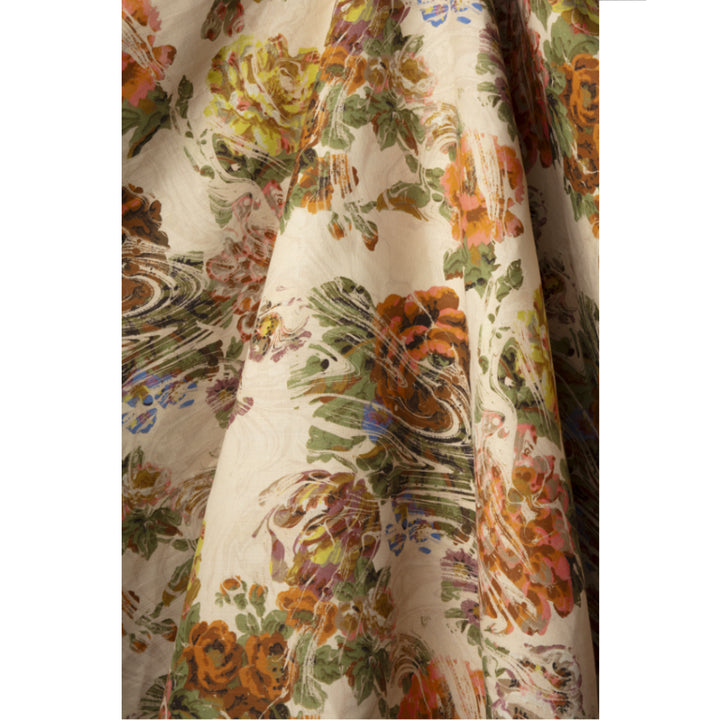 Floral patterned fabric with green foliage and yellow, pink and red flowers on a beige marbled background