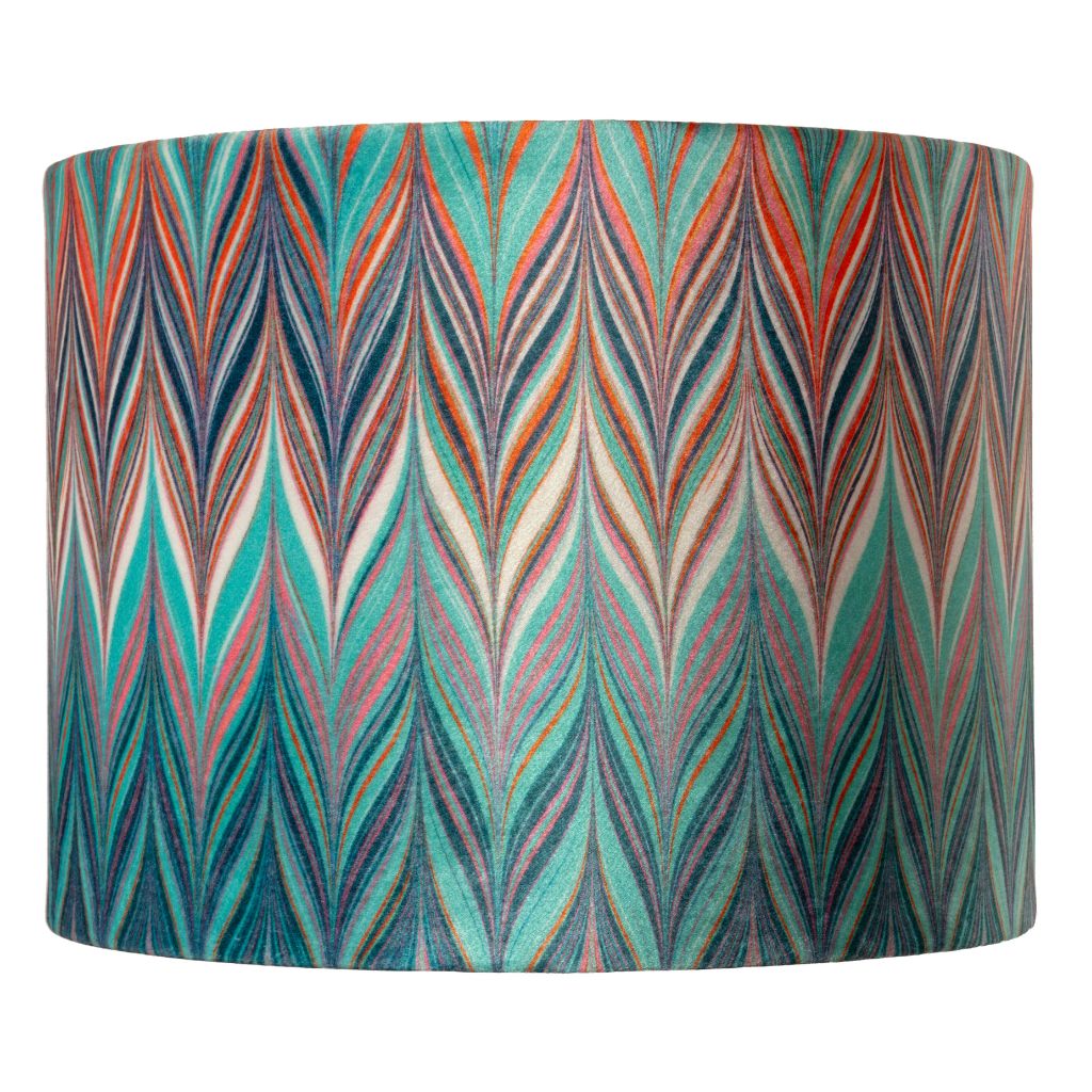 A drum lampshade featuring a vibrant, multicoloured chevron pattern with teal, orange, red, blue, and cream zig zags.