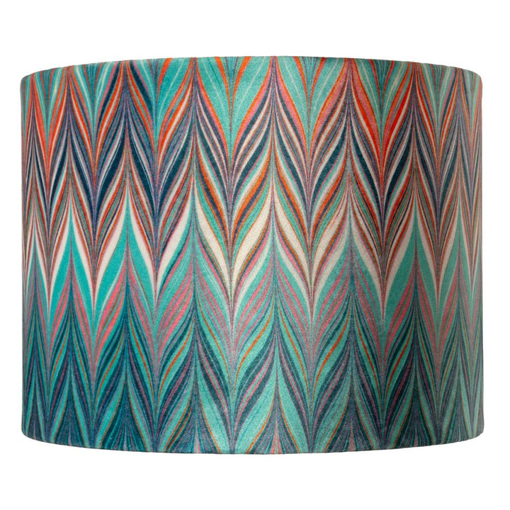 A drum lampshade featuring a vibrant, multicoloured chevron pattern with teal, orange, red, blue, and cream zig zags.