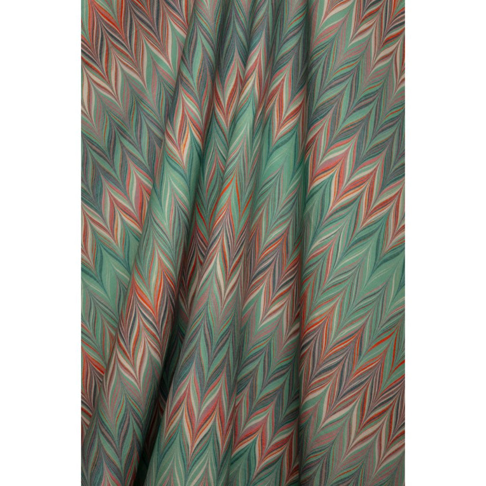 A close-up of a draped fabric with a colorful zigzag chevron pattern in shades of blue, teal, coral, and white