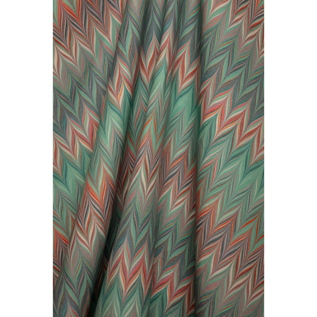 A close-up of a draped fabric with a colorful zigzag chevron pattern in shades of blue, teal, coral, and white