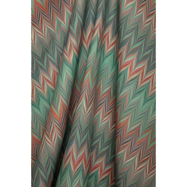 A close-up of a draped fabric with a colorful zigzag chevron pattern in shades of blue, teal, coral, and white