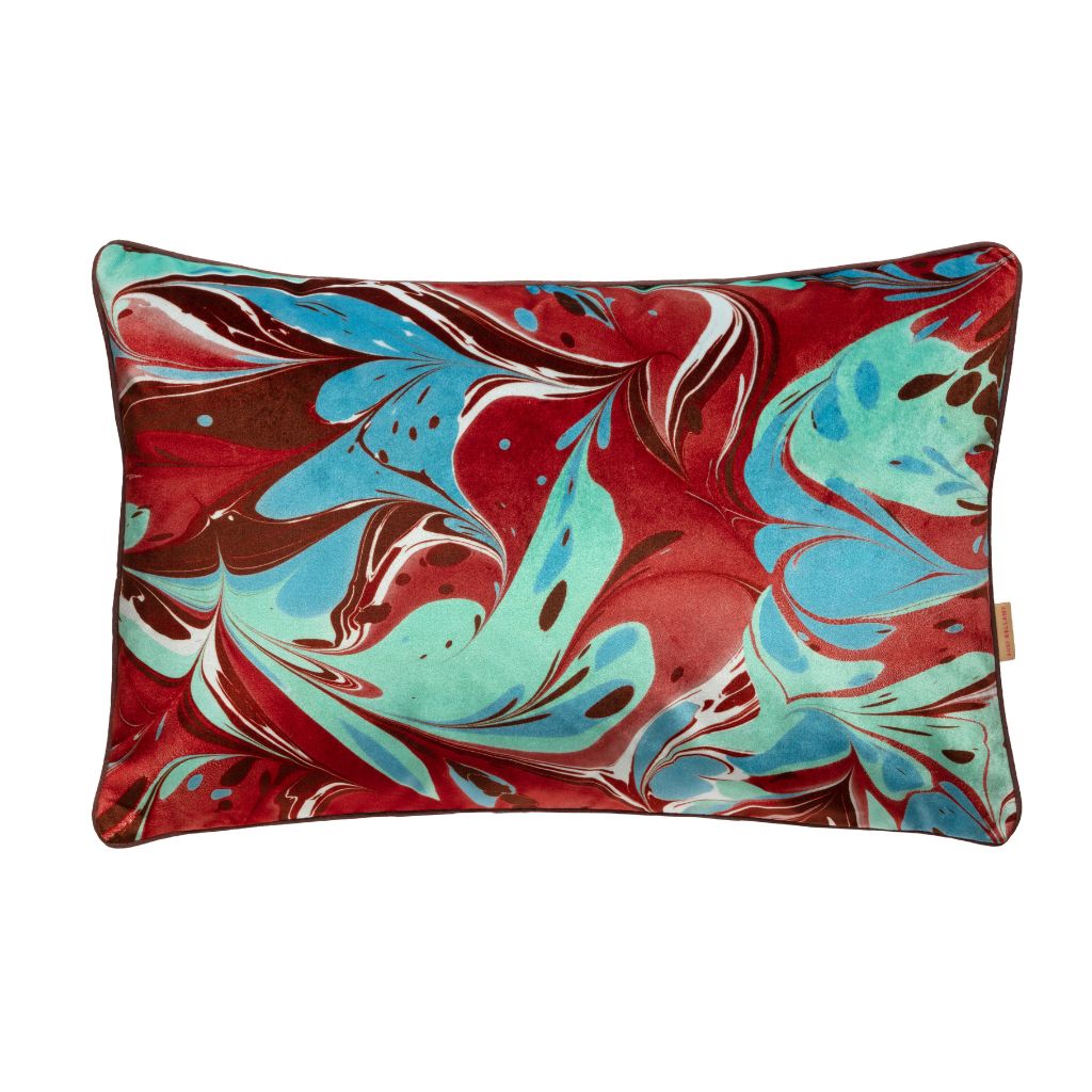 A rectangular lumbar throw pillow featuring a vibrant red, turquoise blue, and brown marbled abstract pattern on a solid white background.