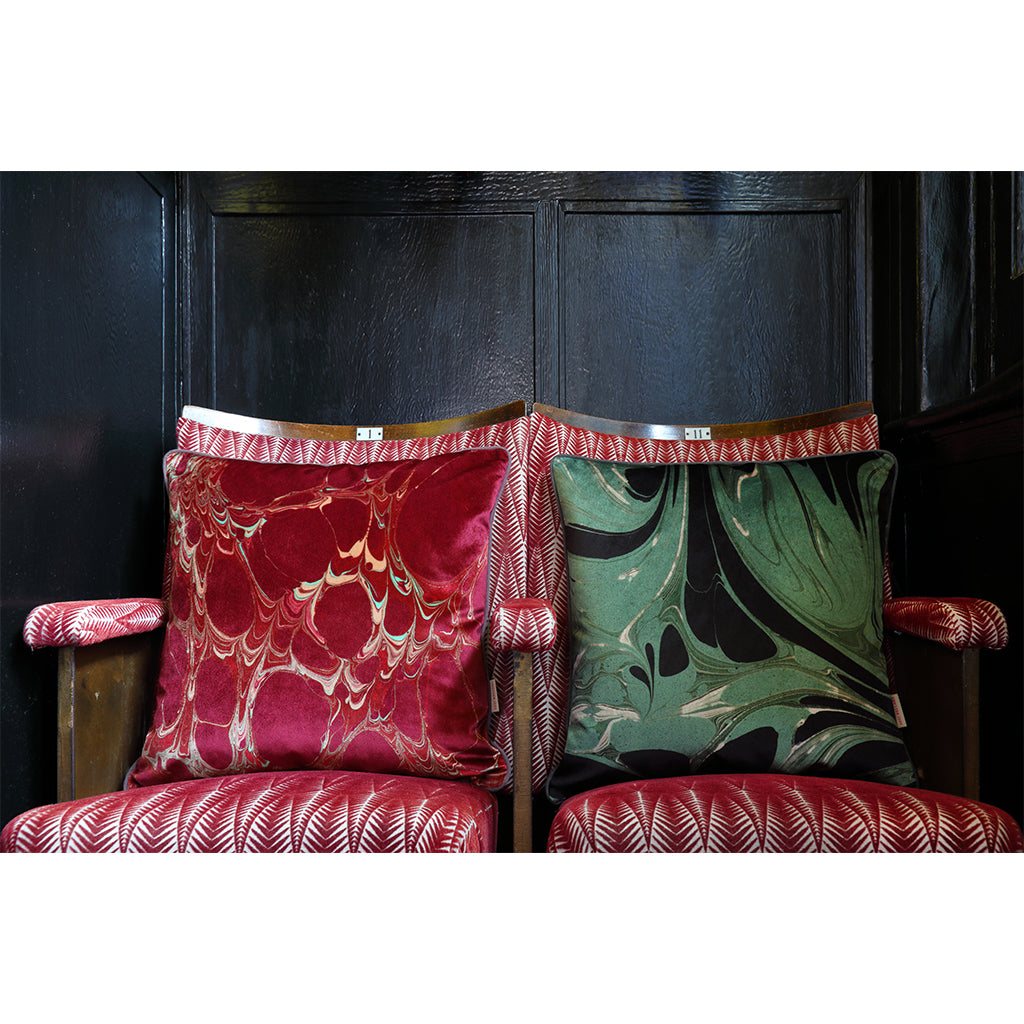 Patterned velvet cushions on red chairs