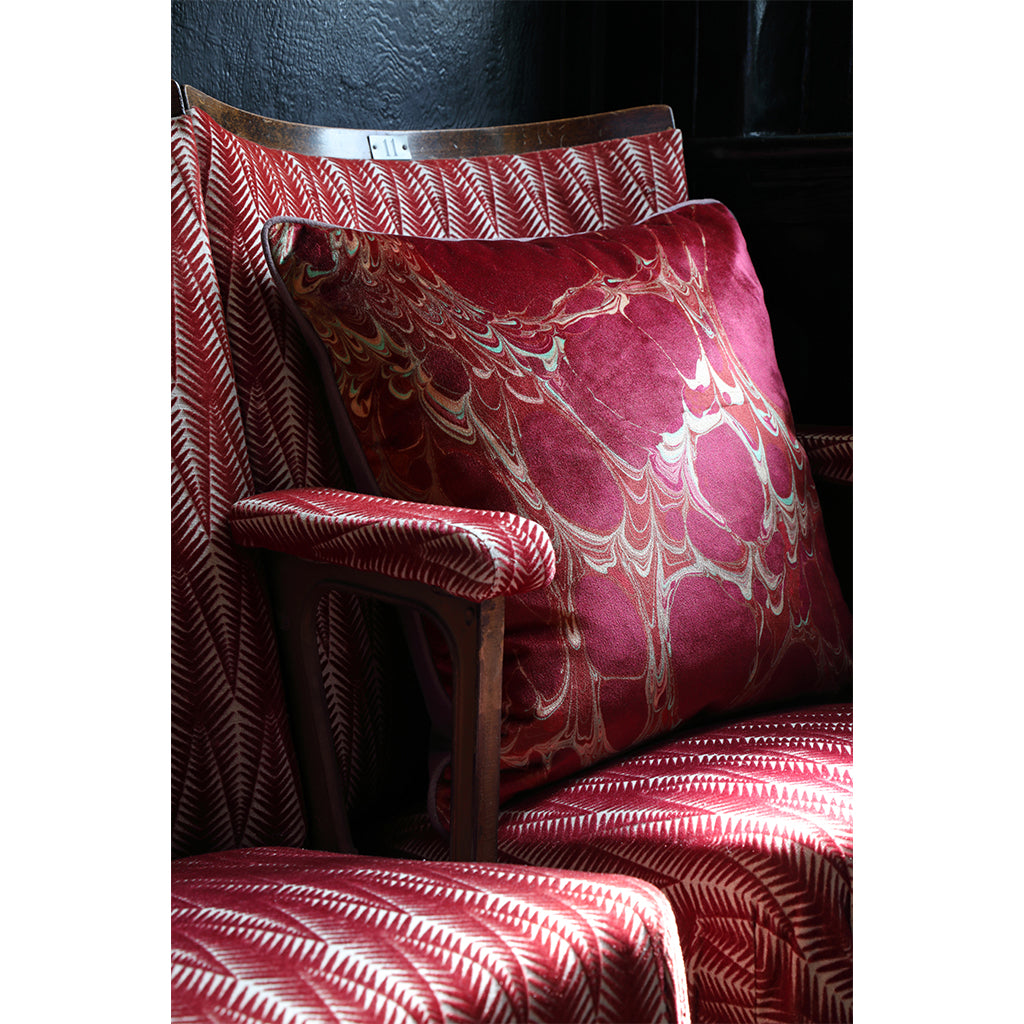 Close up view of red patterned velvet cushion