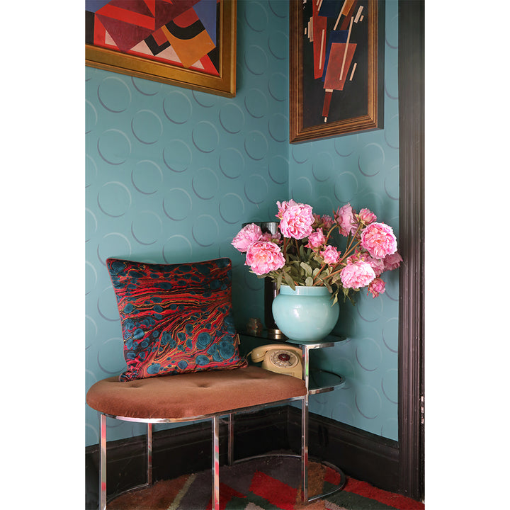 Multicoloured velvet cushions on stool in hallway