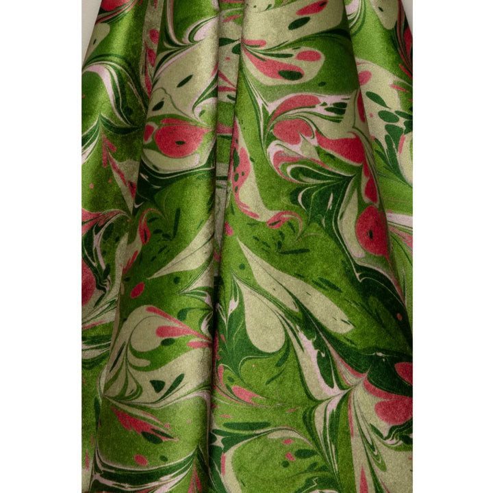A close-up of draped fabric with a marbled pattern in olive green, cream, and pink, shown against a white background.