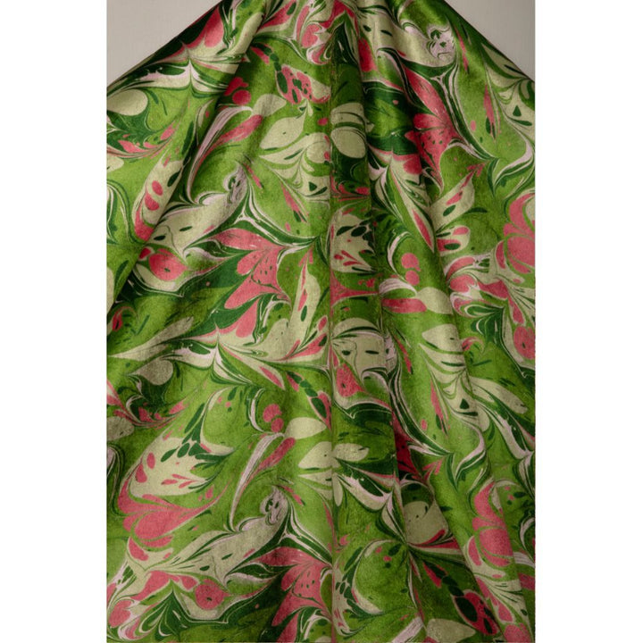 A draped piece of fabric featuring a vibrant green and pink marbled pattern with cream swirls, shown against a neutral gray background.