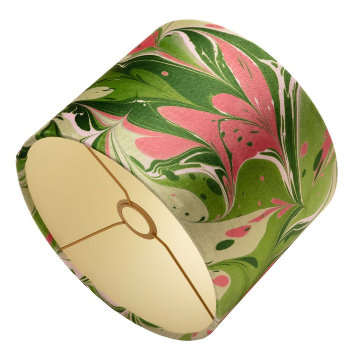 A drum lampshade featuring a green, pink, and cream marbled paper pattern, with a cream lining