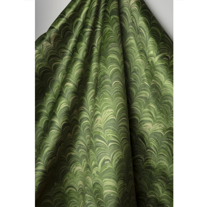 Green fabric with a marbled pattern draped over a surface