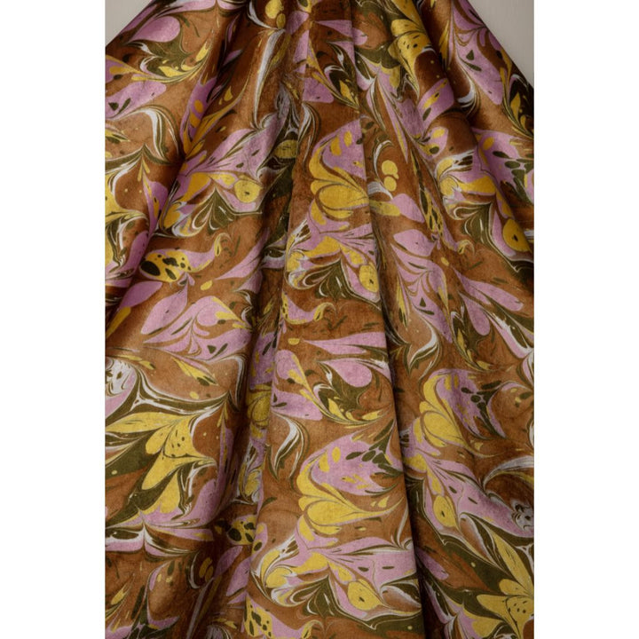 A close-up of draped fabric with an abstract marbled pattern in brown, yellow, pink, olive green, and white.