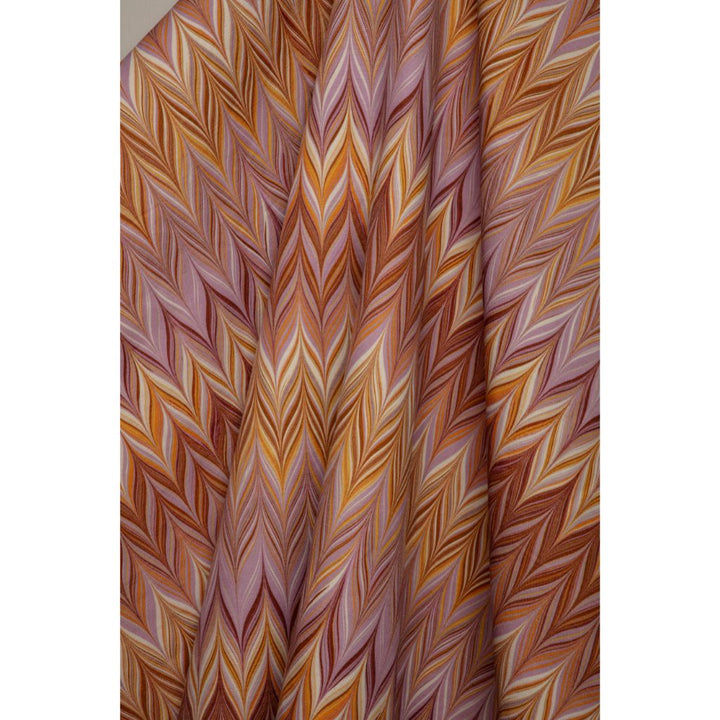 A close-up of a draped fabric with a colorful chevron pattern in shades of orange, brown, pink, and cream.
