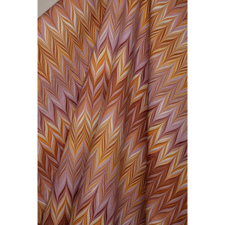 A close-up of a draped fabric with a multi-colored chevron pattern in shades of orange, brown, pink, and beige.