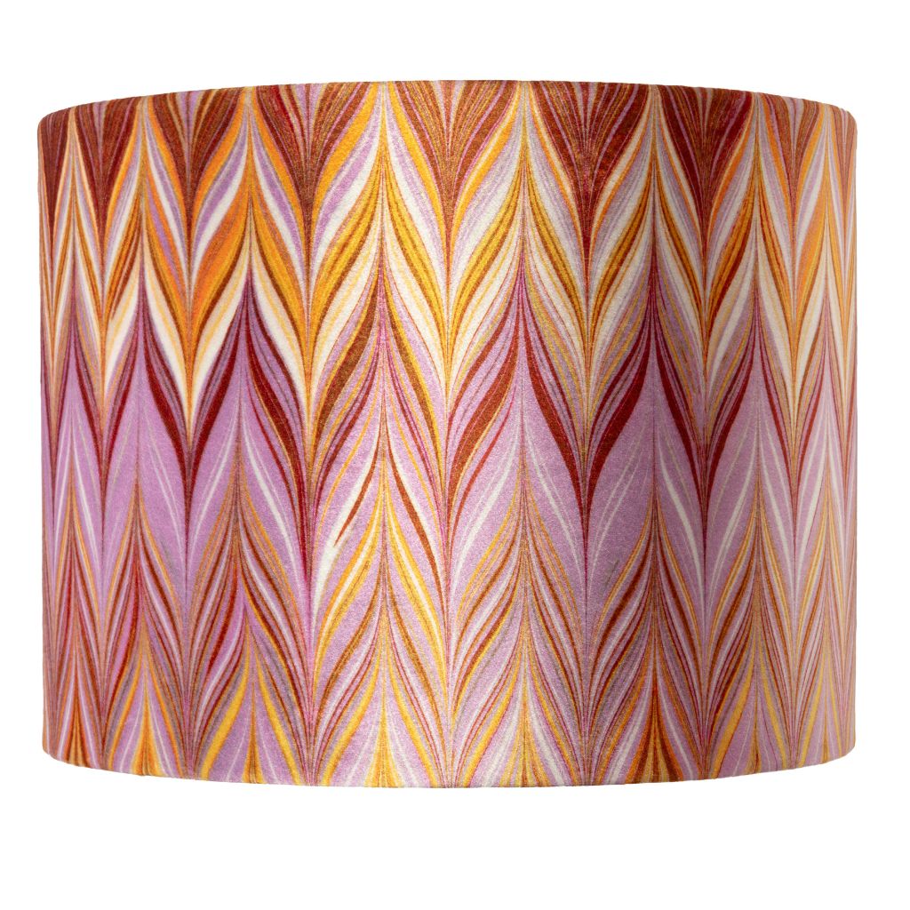 A drum lampshade featuring a vibrant, multicoloured chevron pattern with wavy vertical stripes in shades of orange, yellow, pink, purple, and red on a white background.