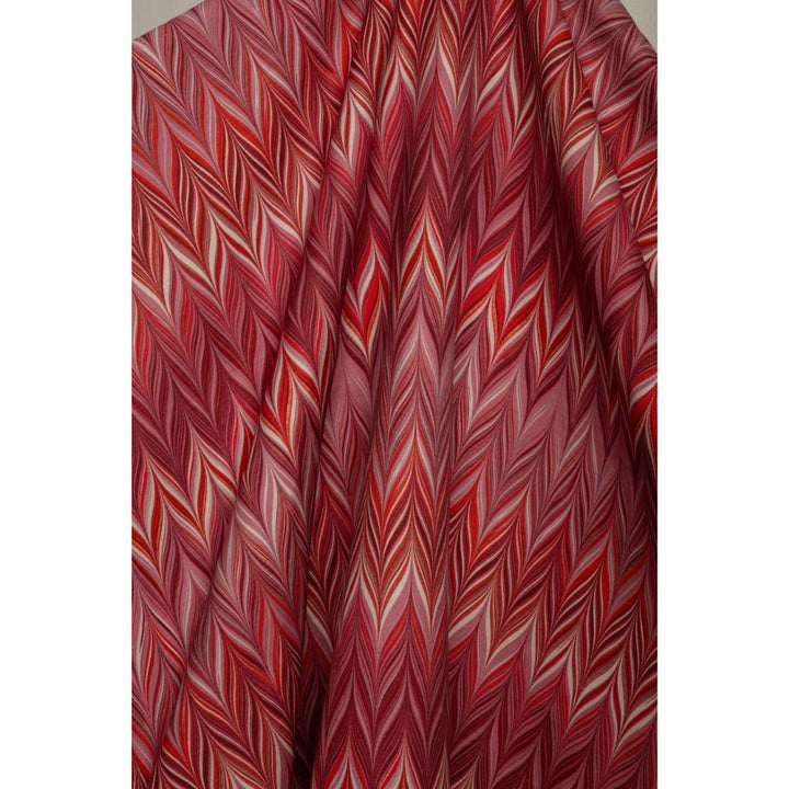 A close-up of draped fabric with a dense, multi-toned chevron pattern in shades of red, pink, and cream.