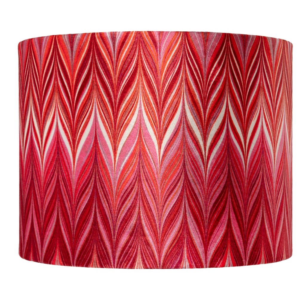 A drum lampshade featuring a vibrant red and pink chevron pattern with white and orange accent lines, set against a plain white background.