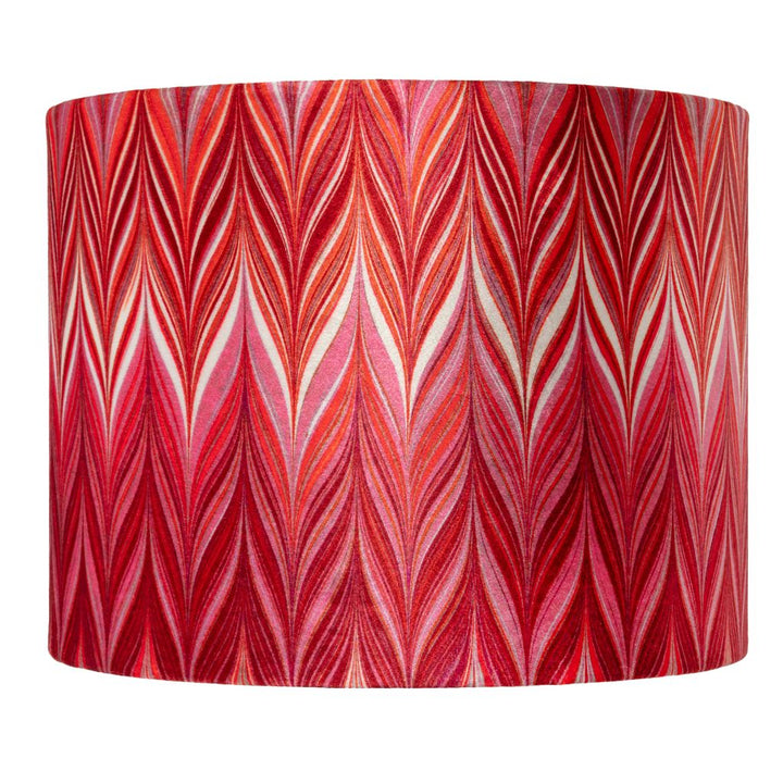A drum lampshade featuring a vibrant red and pink chevron pattern with white and orange accent lines, set against a plain white background.