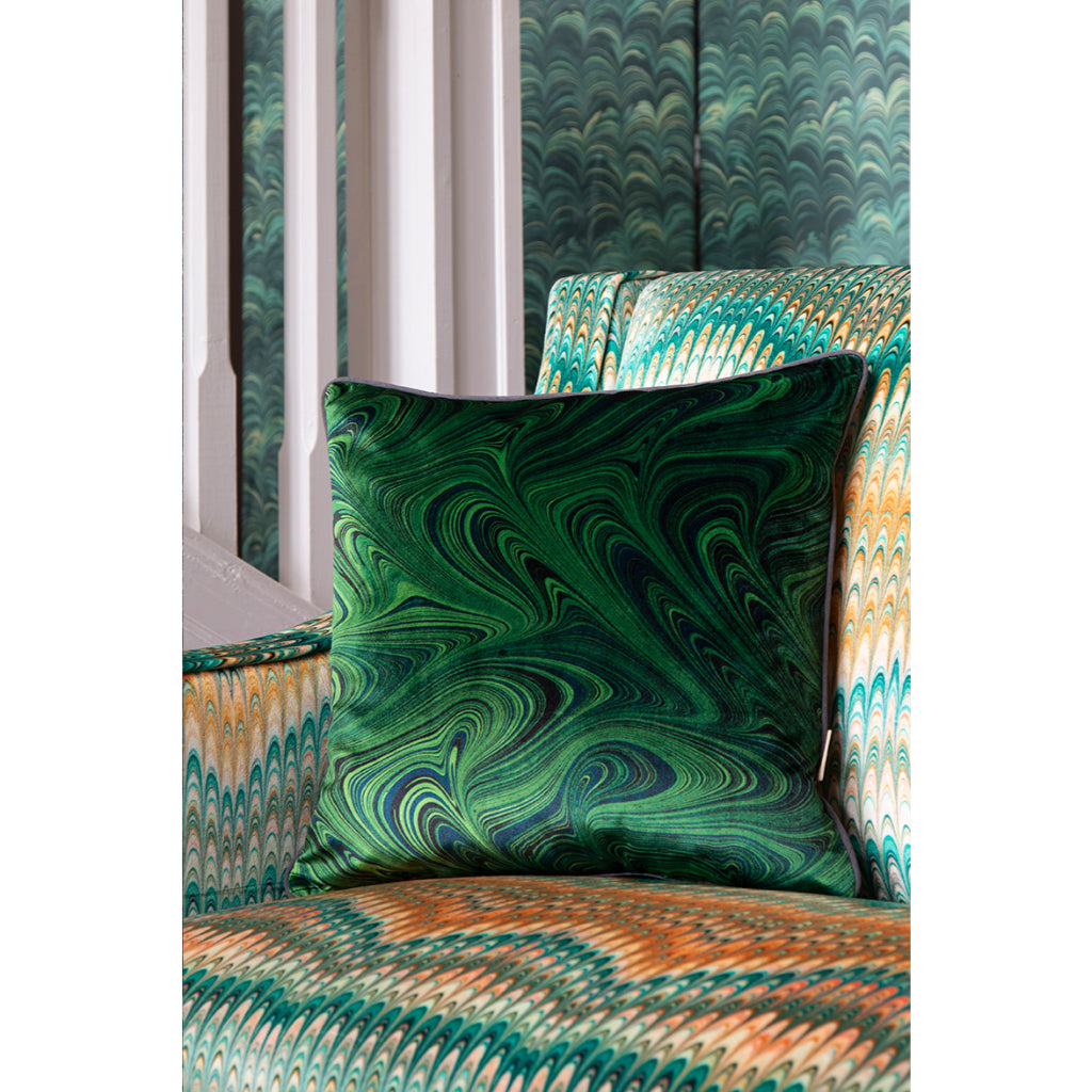 Decorative cushion with green marbled pattern on a chair upholstered in marbled yellow and green velvet fabric