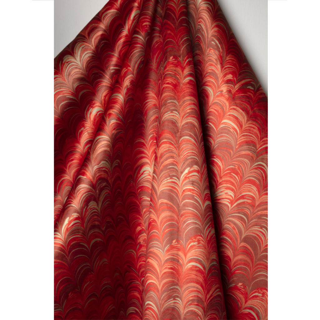Red, orange, mauve and pale blue marbled fabric pattern