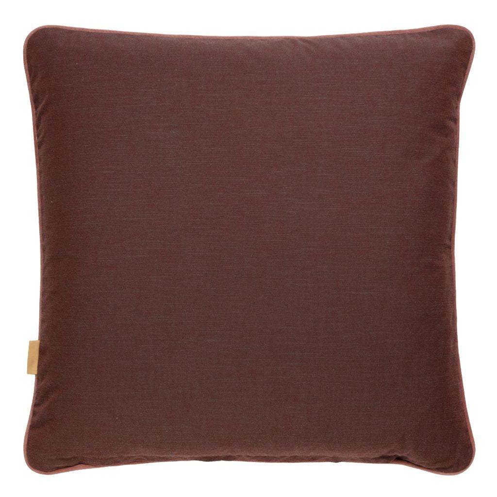 A square throw pillow in a rich dark brown fabric, photographed against a clean white background. A small beige fabric tag is visible on the lower left edge.