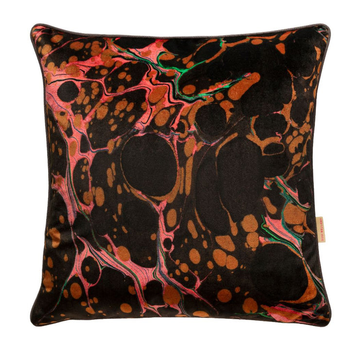 A square throw pillow featuring a black background with an abstract marbled pattern in metallic copper, pink, and green, shown against a plain white background.