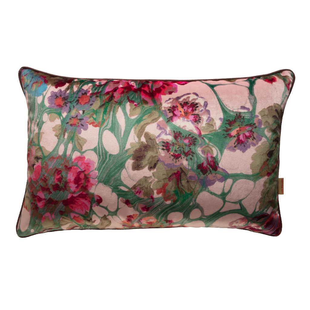 A large oblong velvet cushion with a floral pattern in pink, green, and other colors.