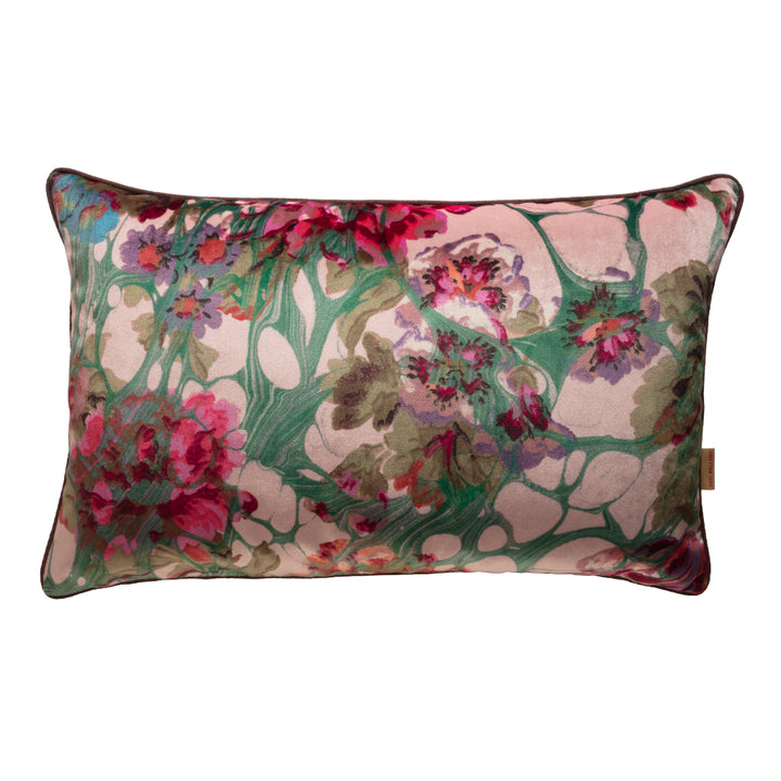 A large oblong velvet cushion with a floral pattern in pink, green, and other colors.