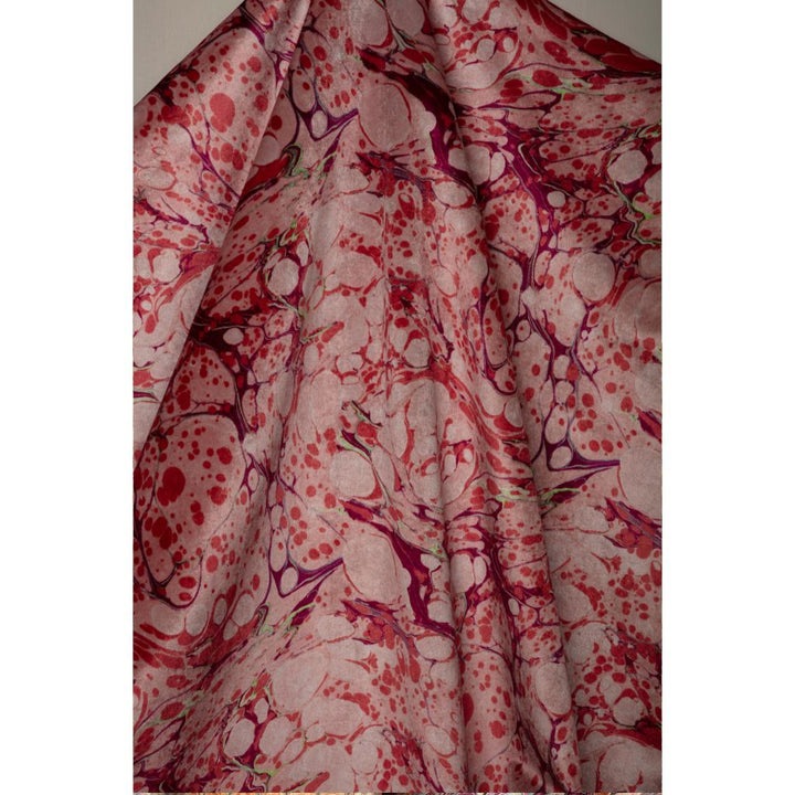 A draped piece of fabric featuring an abstract marbled pattern in shades of red, magenta, and pink over a light bubblegum pink base.