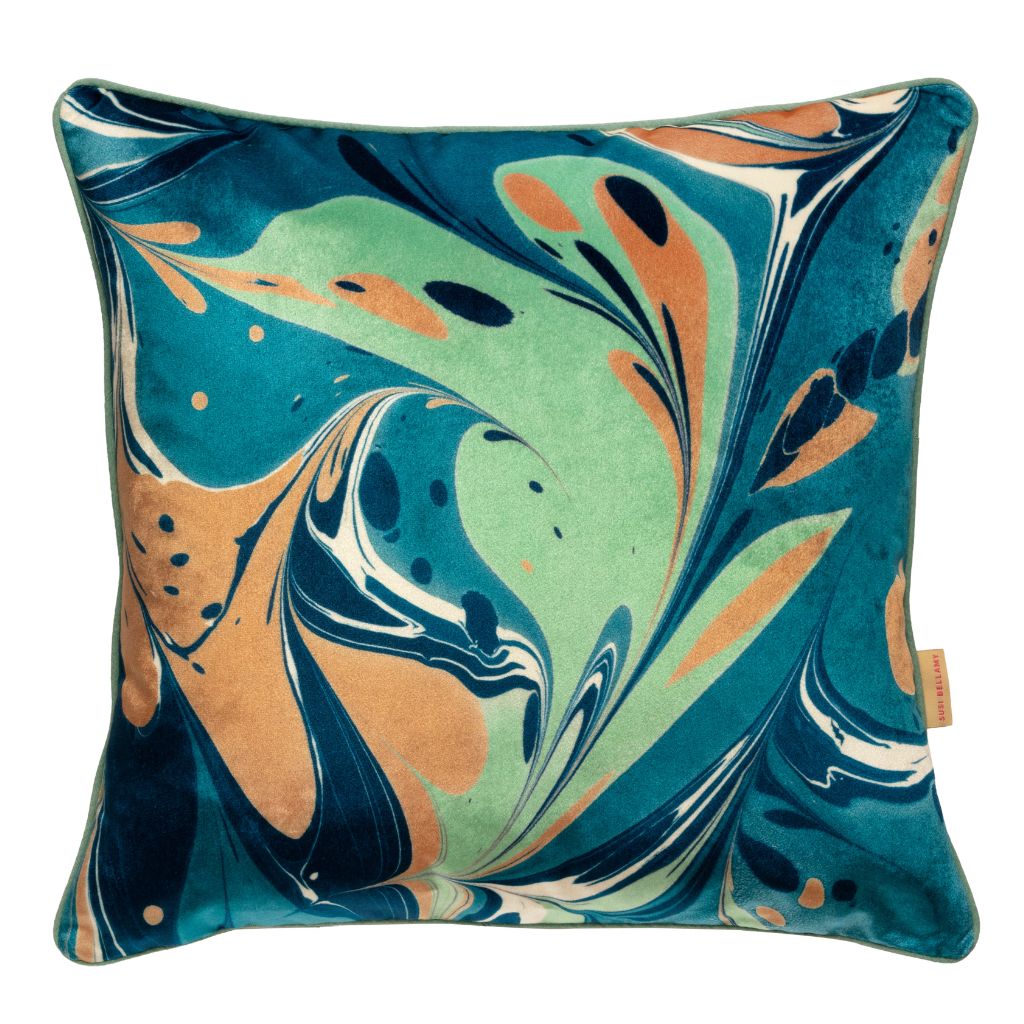 A square throw pillow featuring a marbled abstract pattern in teal, mint green, peach, cream, and navy blue velvet, with a small tan brand tag on the right edge.